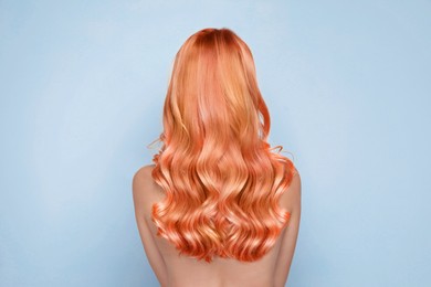 Image of Beautiful woman with long orange hair on light blue background