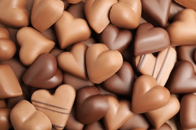 Photo of Tasty heart shaped chocolate candies as background, top view. Valentine's day celebration