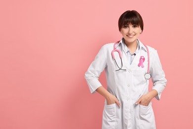 Photo of Mammologist with pink ribbon on color background, space for text. Breast cancer awareness