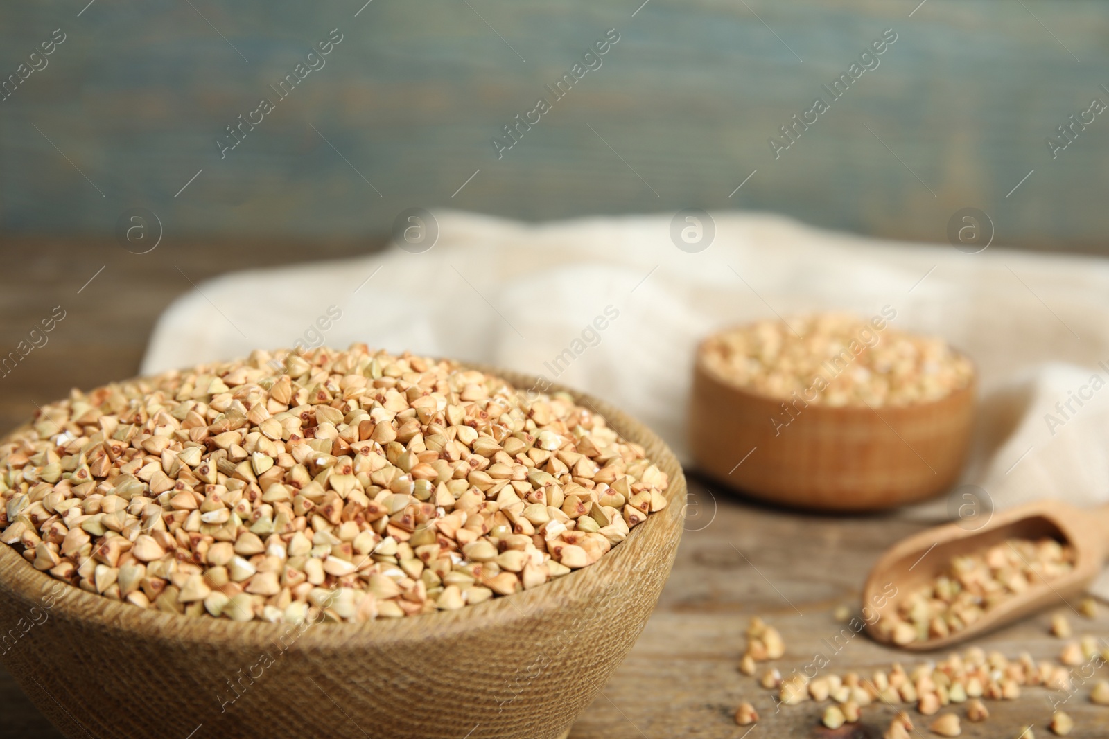 Photo of Uncooked green buckwheat grains in bowl on table