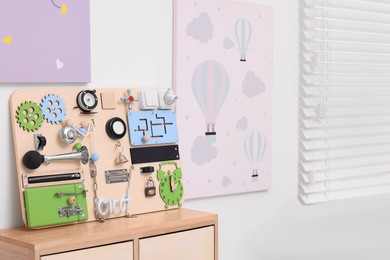 Photo of Colorful busy board and cute posters on wall in room. Kindergarten interior