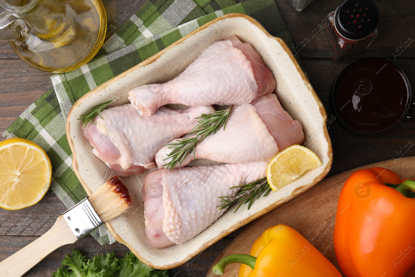 Photo of Flat lay composition with marinade and raw chicken drumsticks on wooden table