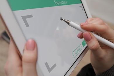 Electronic signature. Woman using stylus and tablet, closeup