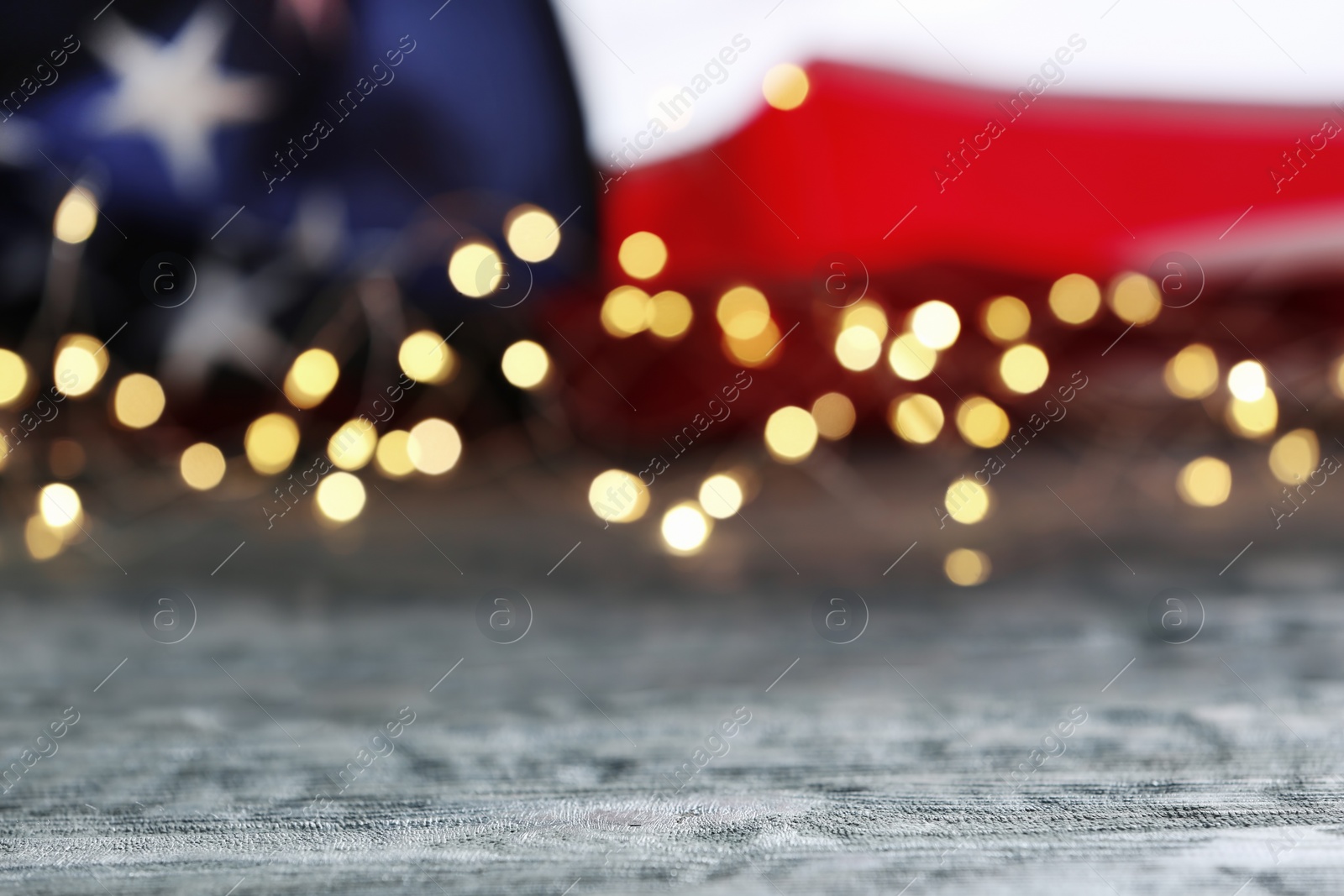 Photo of Blurred lights and American flag on wooden table. Mockup for design
