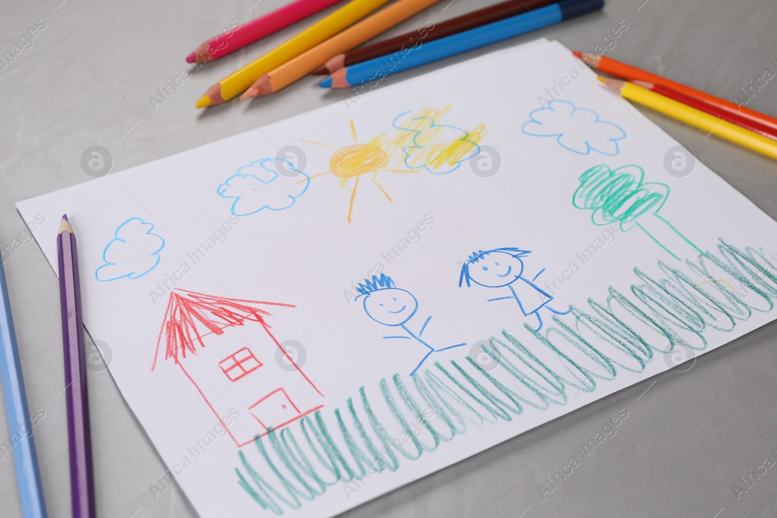 Photo of Cute child`s drawing and colorful pencils on grey textured table