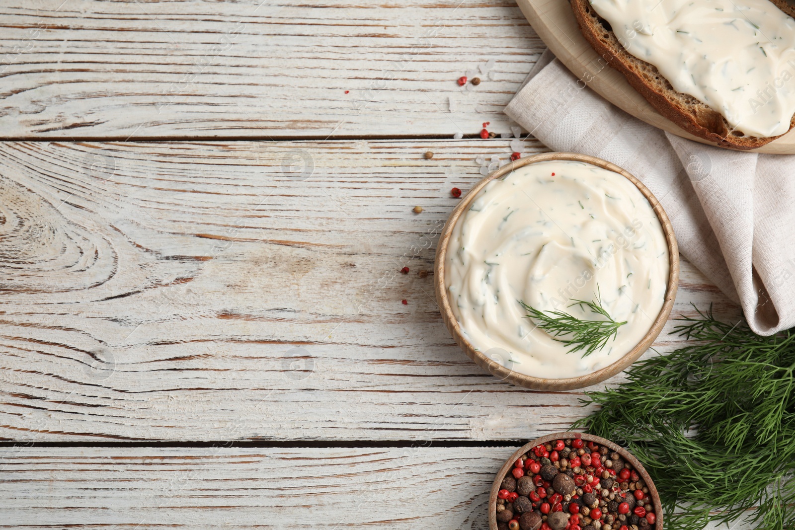 Photo of Tasty creamy dill sauce, ingredients and sandwich on white wooden table, flat lay. Space for text