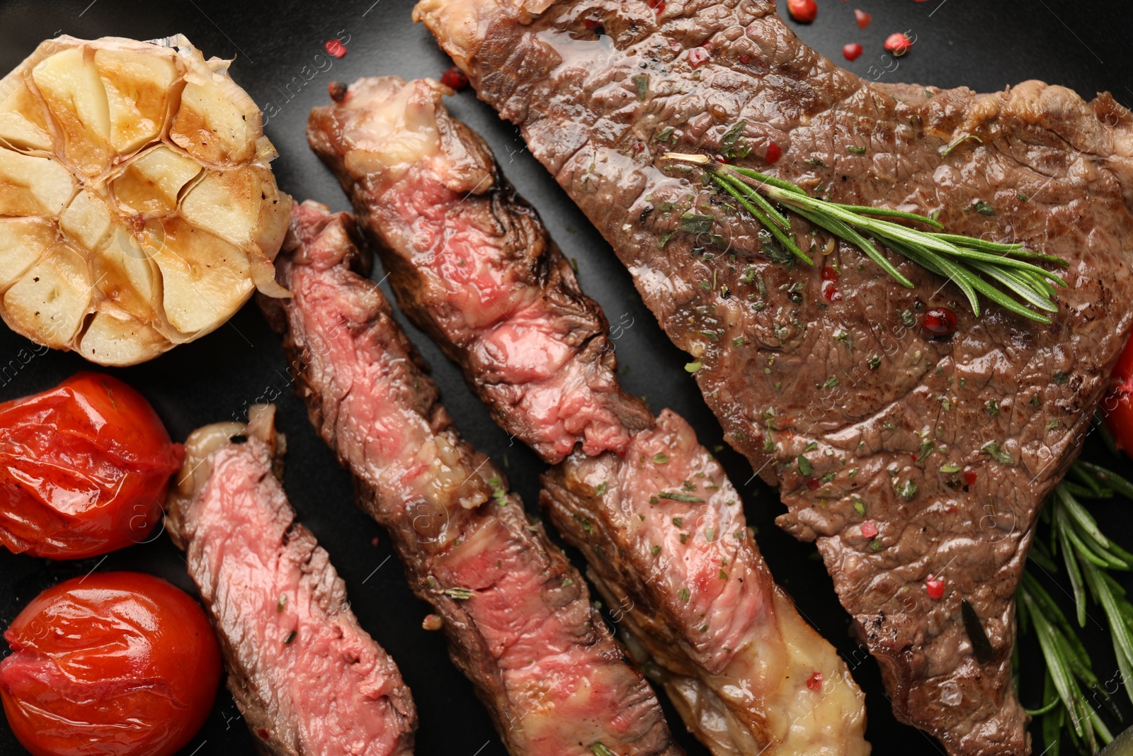 Photo of Delicious grilled beef steak with vegetables and spices on plate, top view