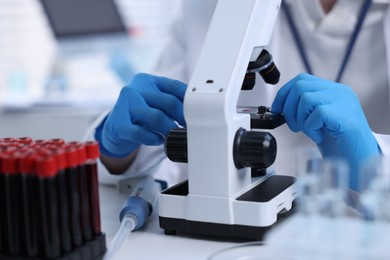 Scientist working with microscope in laboratory, closeup