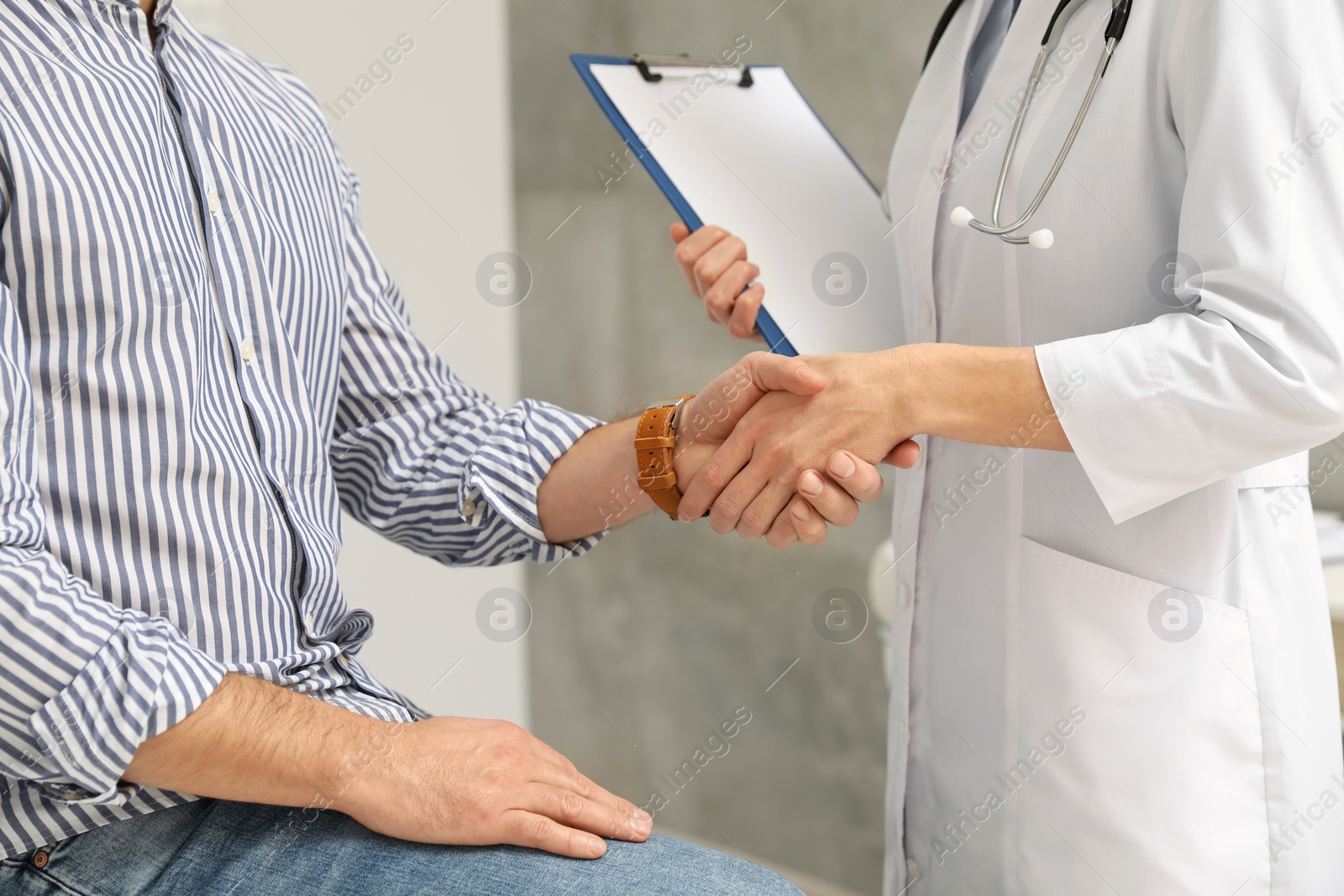 Photo of Doctor shaking hands with patient in hospital, closeup