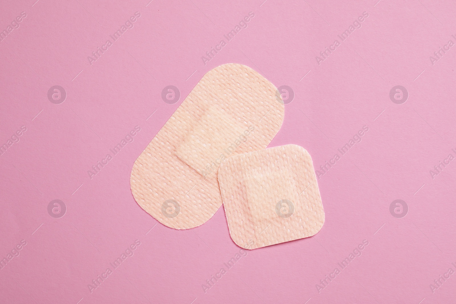 Photo of Contraceptive patches on pink background, top view