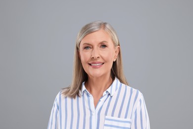Portrait of beautiful middle aged woman on light grey background