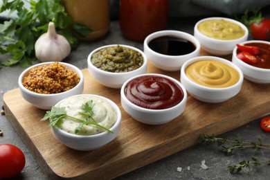 Many different sauces and products on grey table