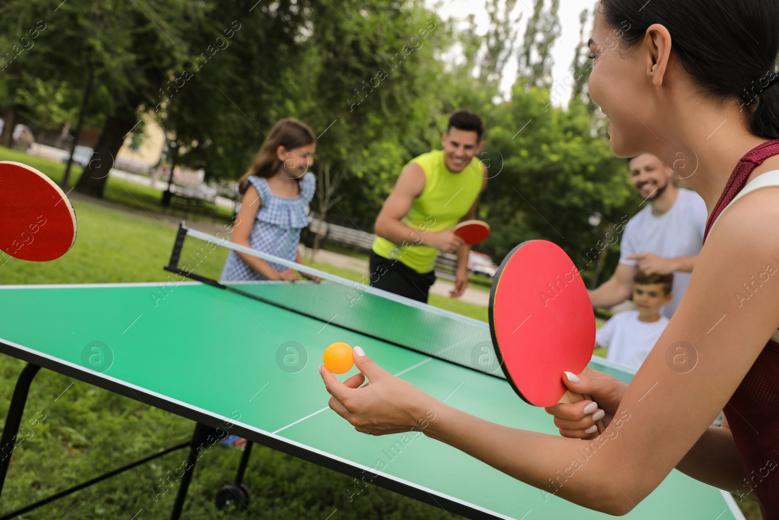 Photo of Happy families playing ping pong in park