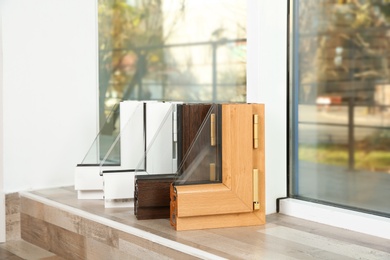 Photo of Samples of modern window profiles on sill indoors, space for text. Installation service