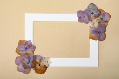 Frame with wild dried meadow flowers on beige background, flat lay. Space for text