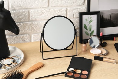 Photo of Dressing table with mirror, makeup products and accessories in room