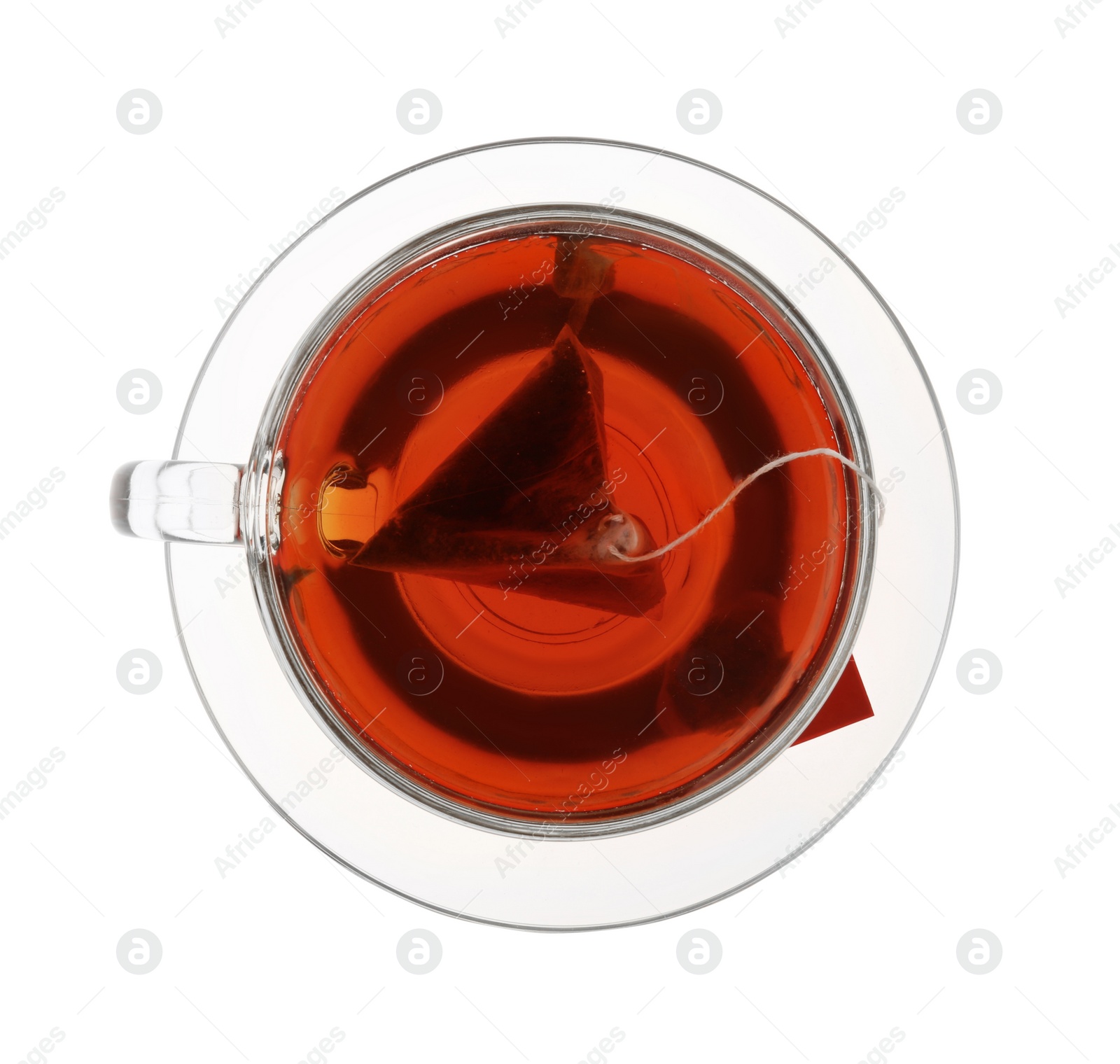 Photo of Tea bag in glass cup of hot water isolated on white, top view