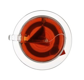 Photo of Tea bag in glass cup of hot water isolated on white, top view