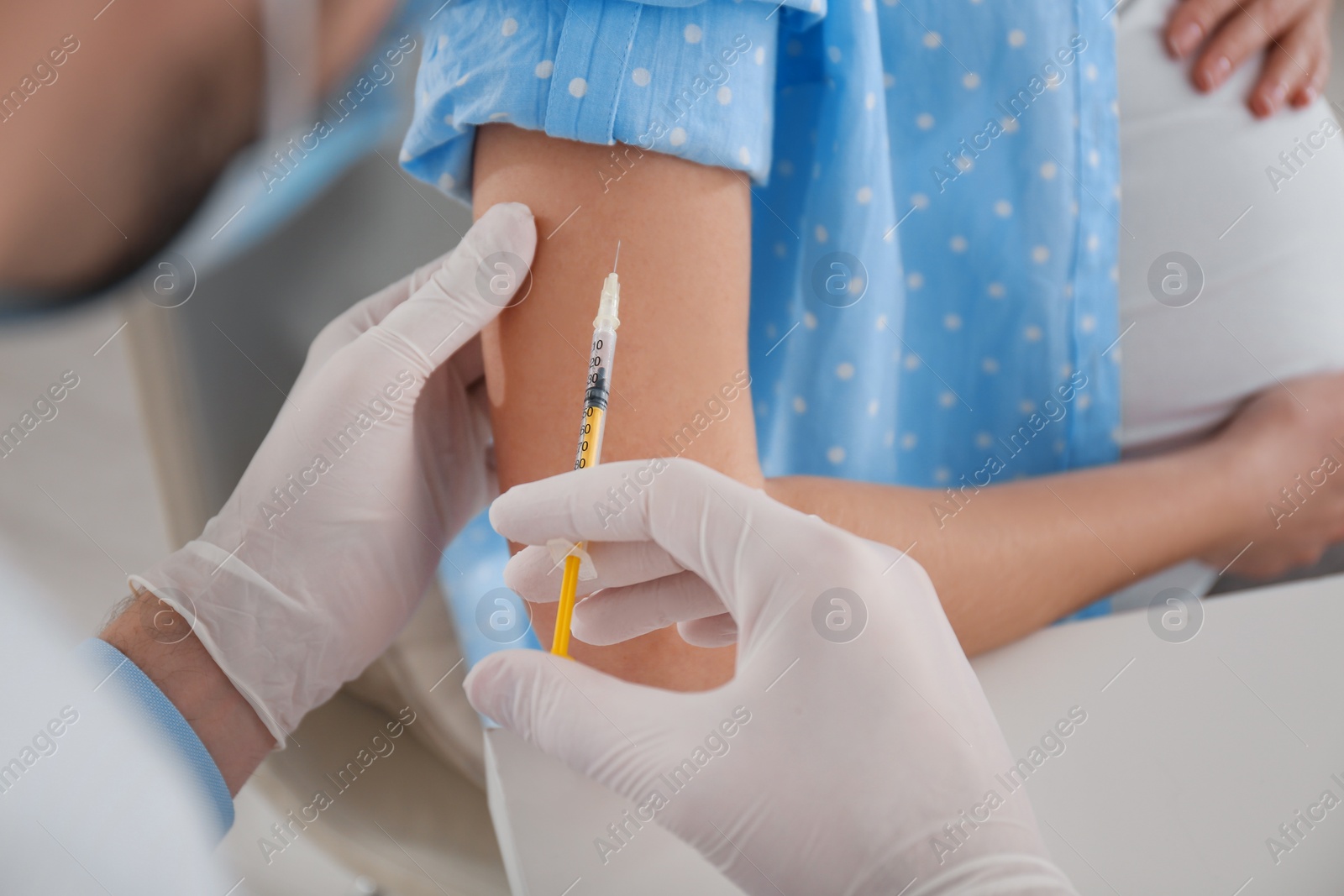 Photo of Doctor vaccinating pregnant woman against coronavirus in clinic, closeup