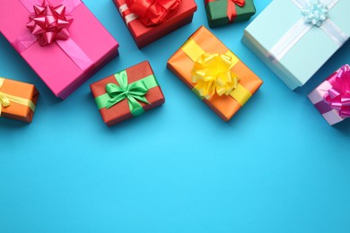 Many colorful gift boxes on light blue background, flat lay. Space for text