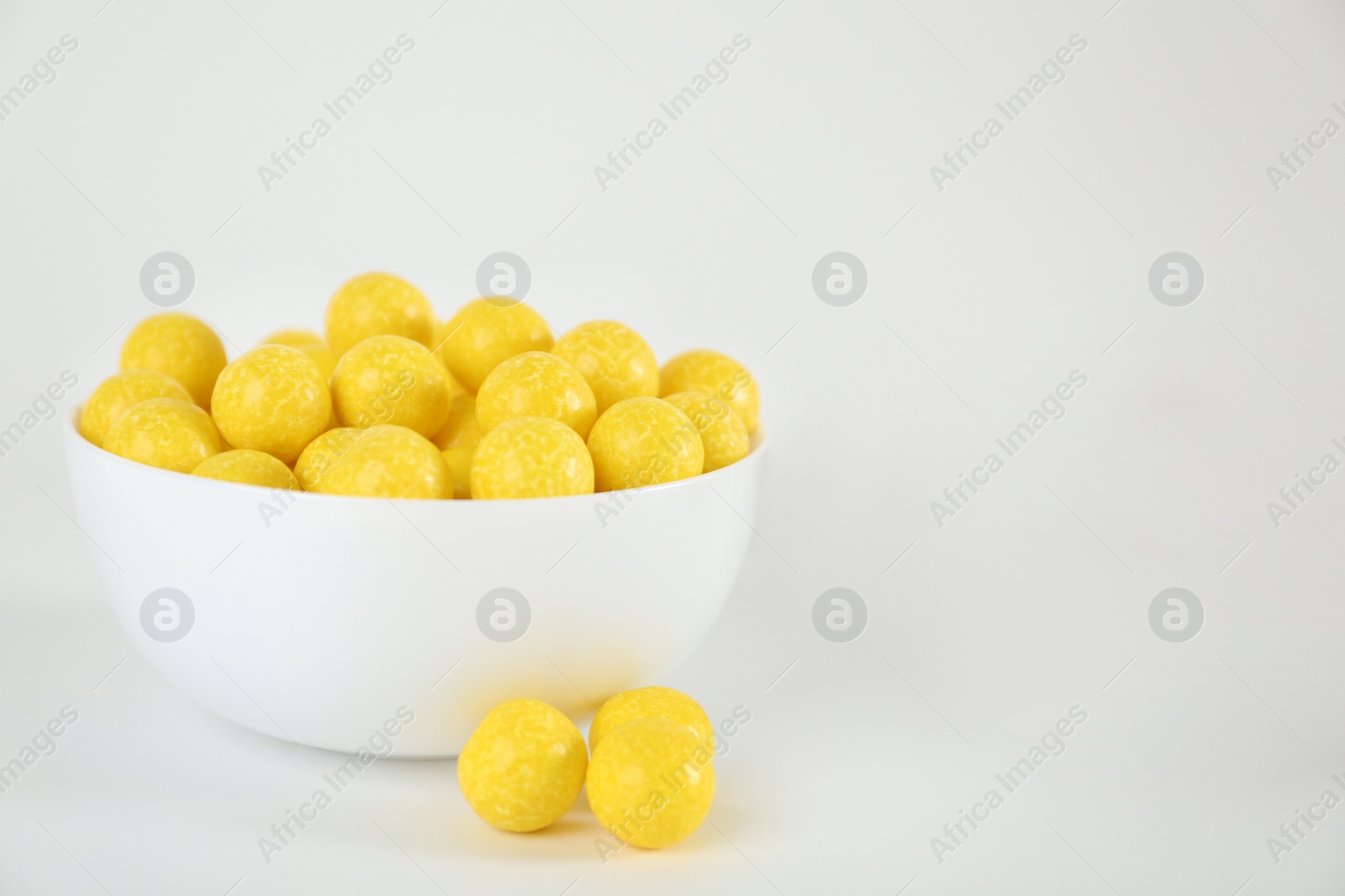 Photo of Tasty small lemon drops on white background