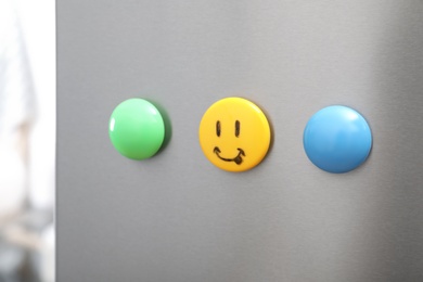 Colorful magnets on refrigerator door in kitchen