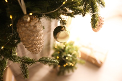 Photo of Beautifully decorated Christmas tree in room, closeup. Interior design
