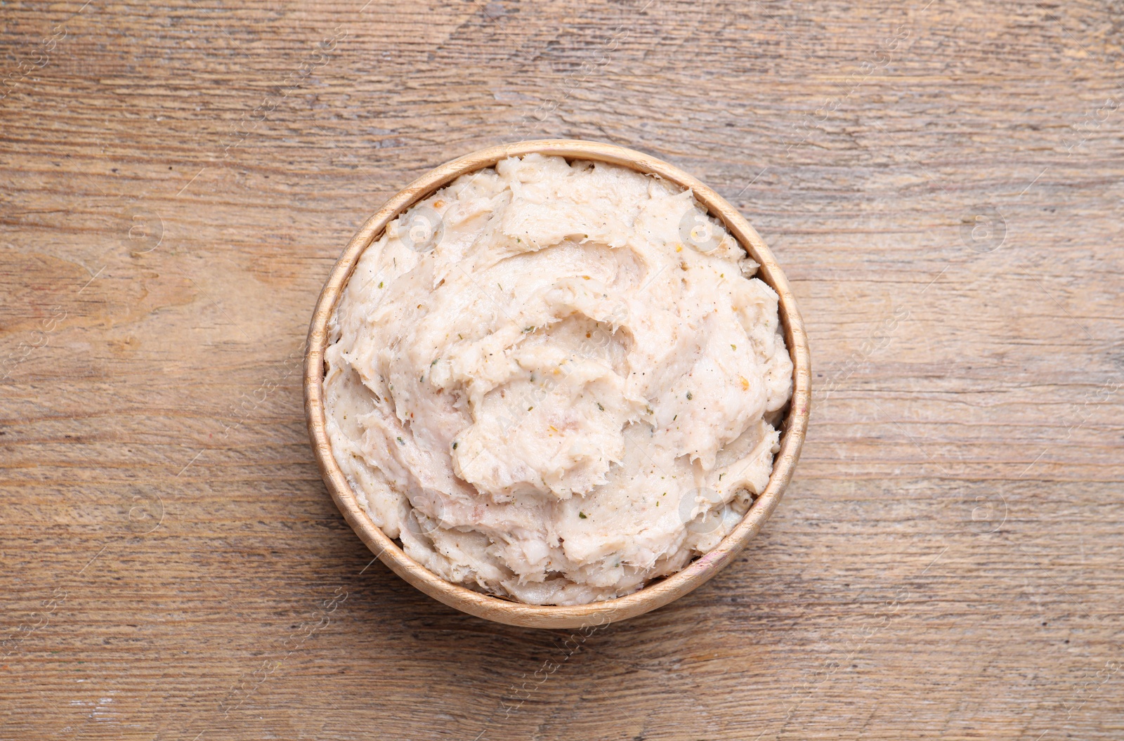 Photo of Pork lard spread in bowl on wooden table, top view