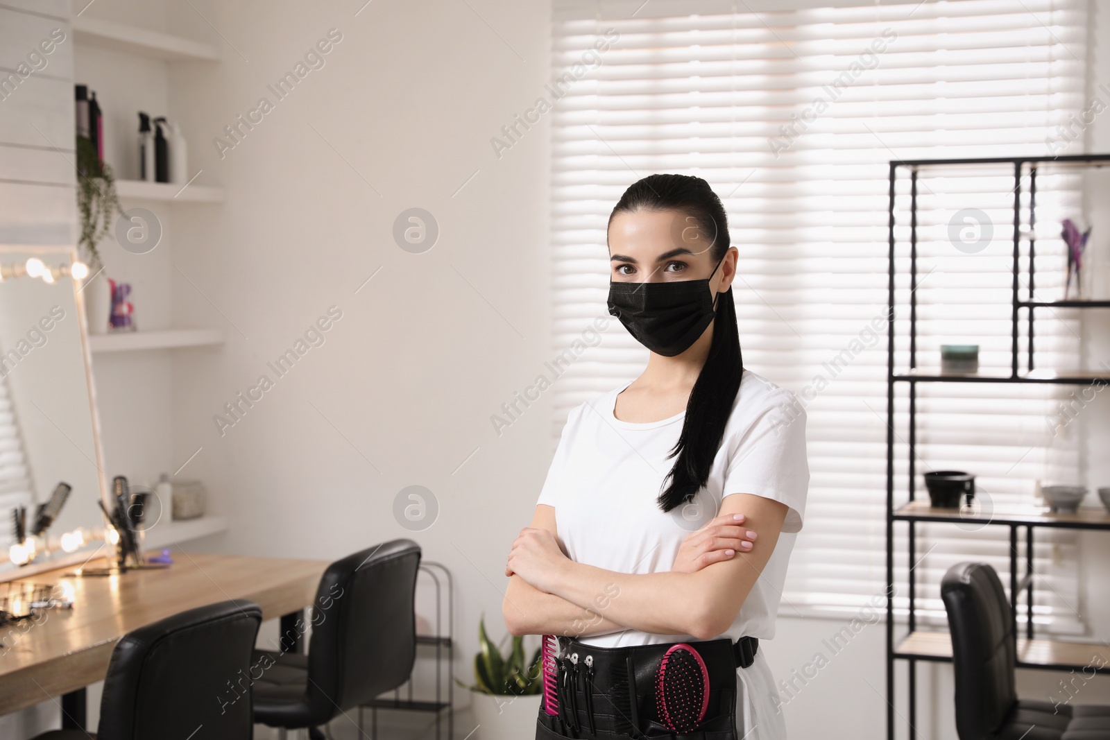 Photo of Professional stylist with protective mask in salon, space for text. Hairdressing services during Coronavirus quarantine