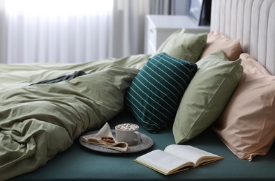 Photo of Comfortable bed with new pistachio linens in modern room interior