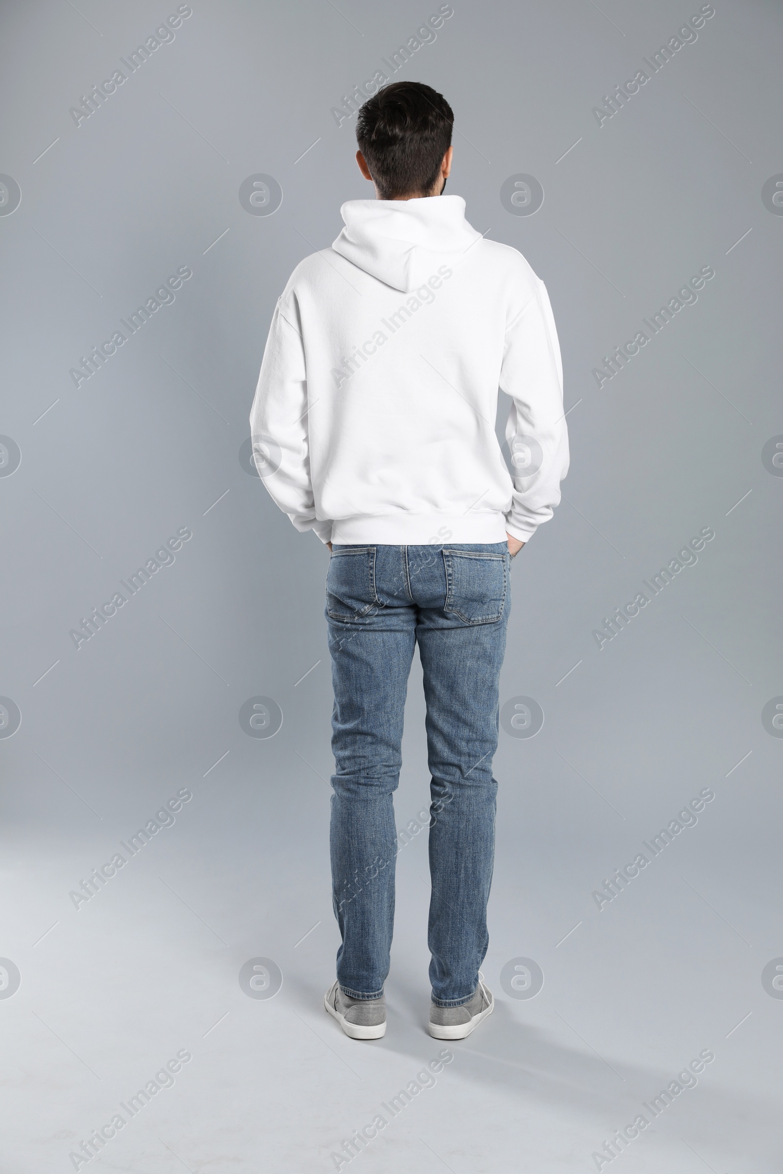 Photo of Young man in sweater on grey background. Mock up for design