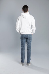 Young man in sweater on grey background. Mock up for design