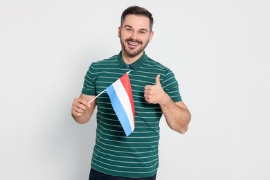 Photo of Man with flag of Netherlands showing thumb up on white background