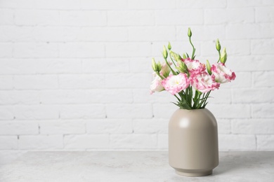 Photo of Beautiful flowers in vase and space for text on blurred background. Element of interior design