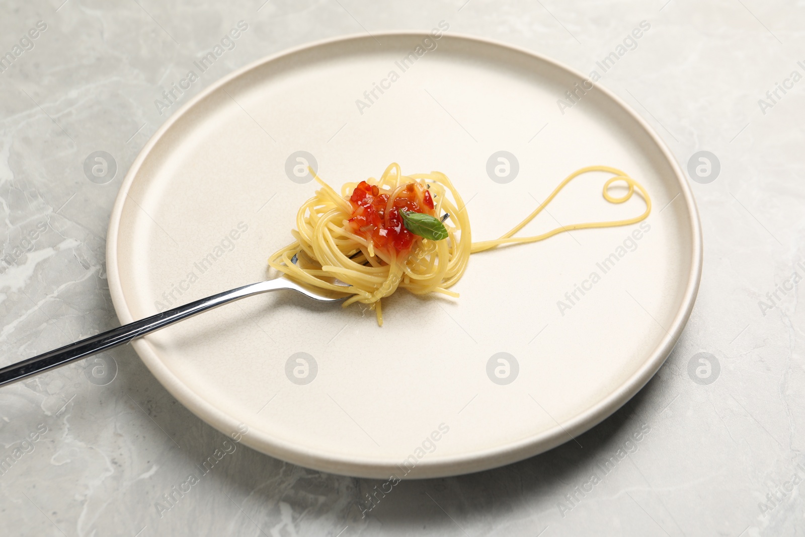 Photo of Heart made with spaghetti and fork on grey table