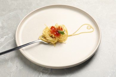 Photo of Heart made with spaghetti and fork on grey table