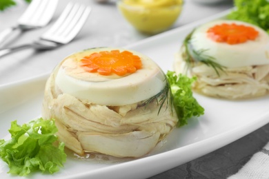 Photo of Delicious chicken aspic with eggs and vegetables on plate, closeup