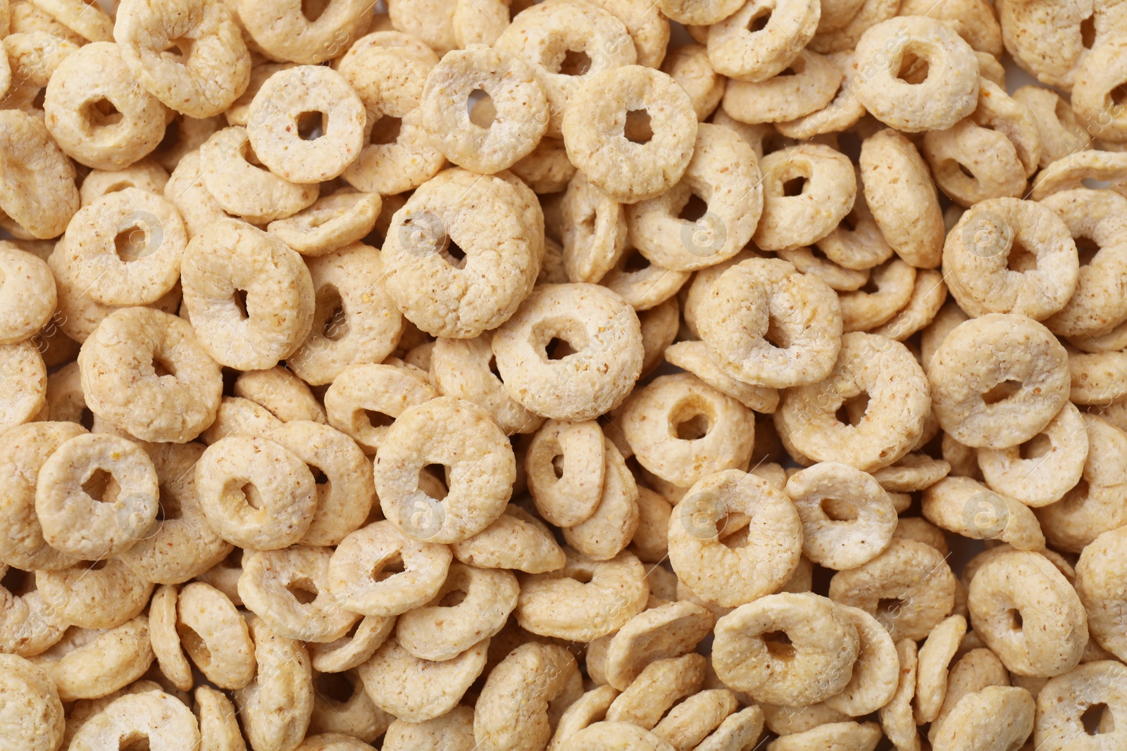 Photo of Tasty sweet cereal rings as background, top view