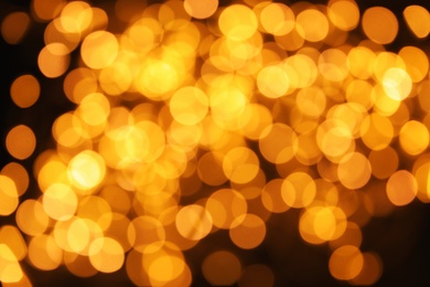 Photo of Gold glitter with bokeh effect on dark background