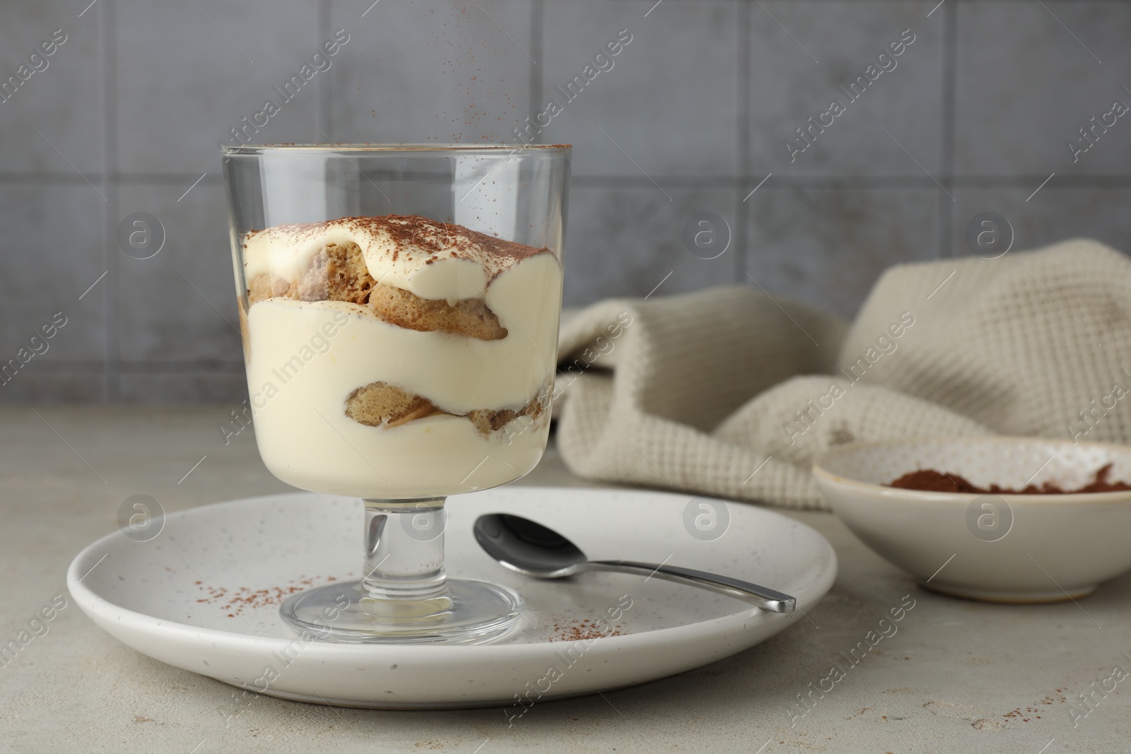 Photo of Delicious tiramisu in glass on light table. Space for text