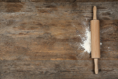 Flour and rolling pin on wooden table, flat lay