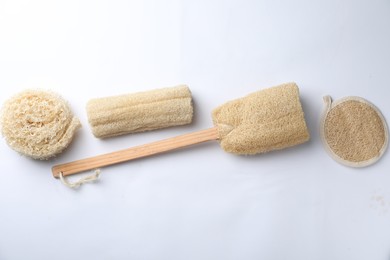 Photo of Natural shower loofah sponges on white background, top view