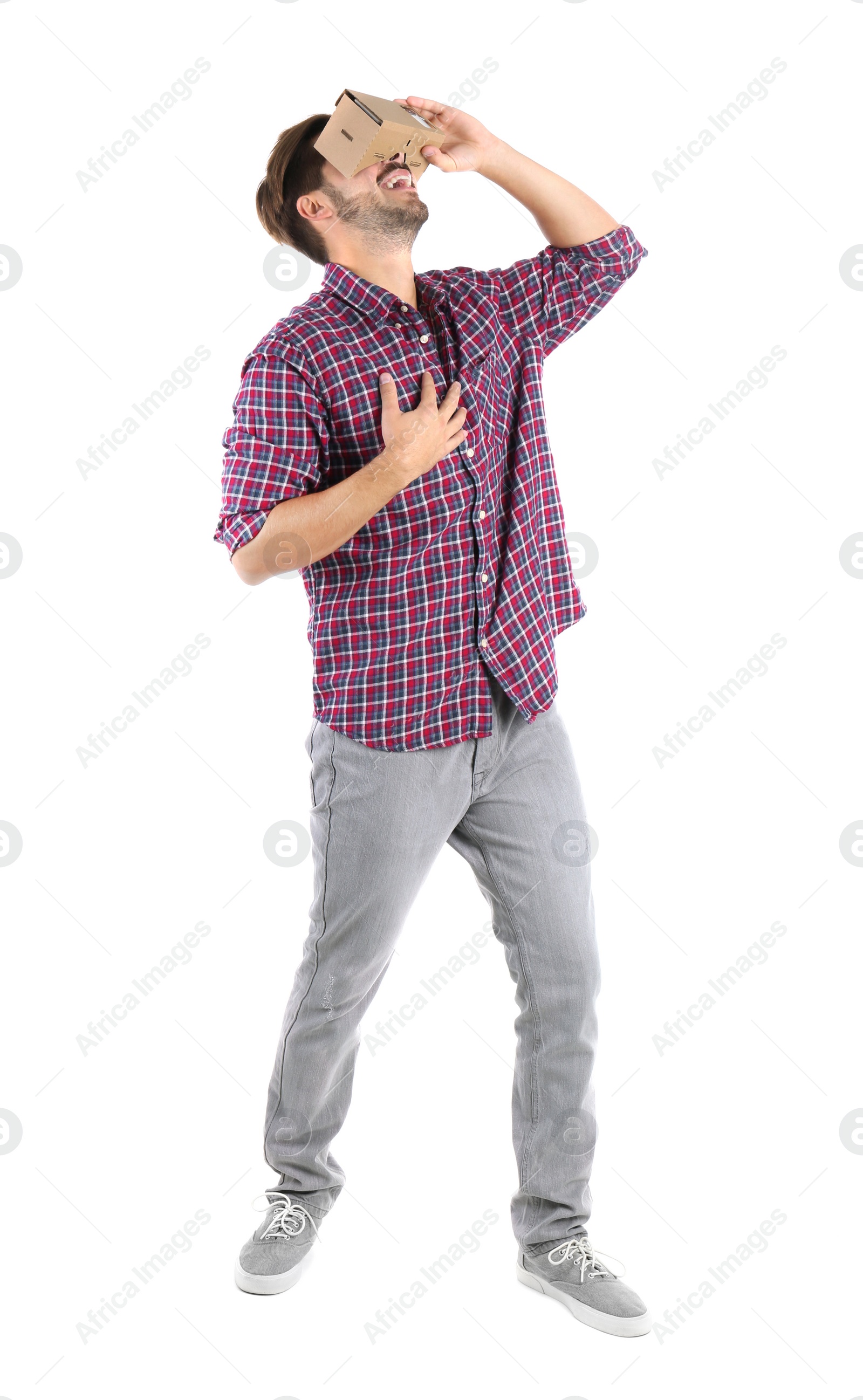 Photo of Young man using cardboard virtual reality headset, isolated on white