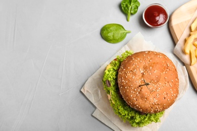 Flat lay composition with tasty burger on table. Space for text