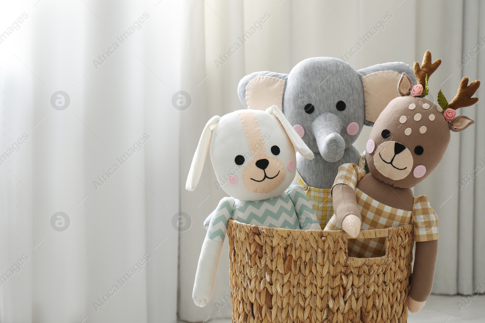 Photo of Funny toys in basket on floor, space for text. Children's room interior design