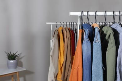 Racks with stylish clothes indoors. Fast fashion