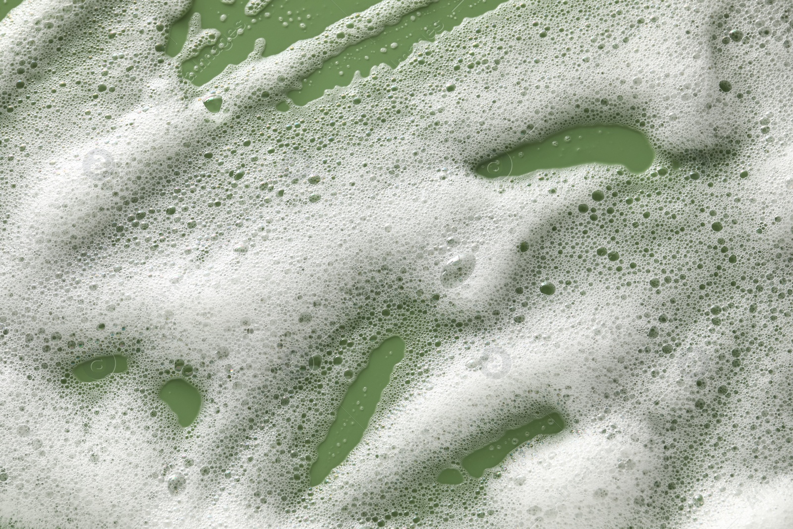 Photo of White washing foam on olive background, top view