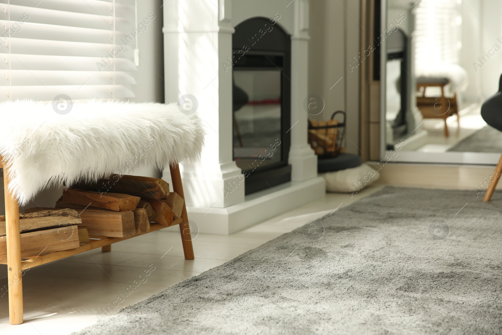 Photo of Bright living room interior with firewood and artificial fireplace