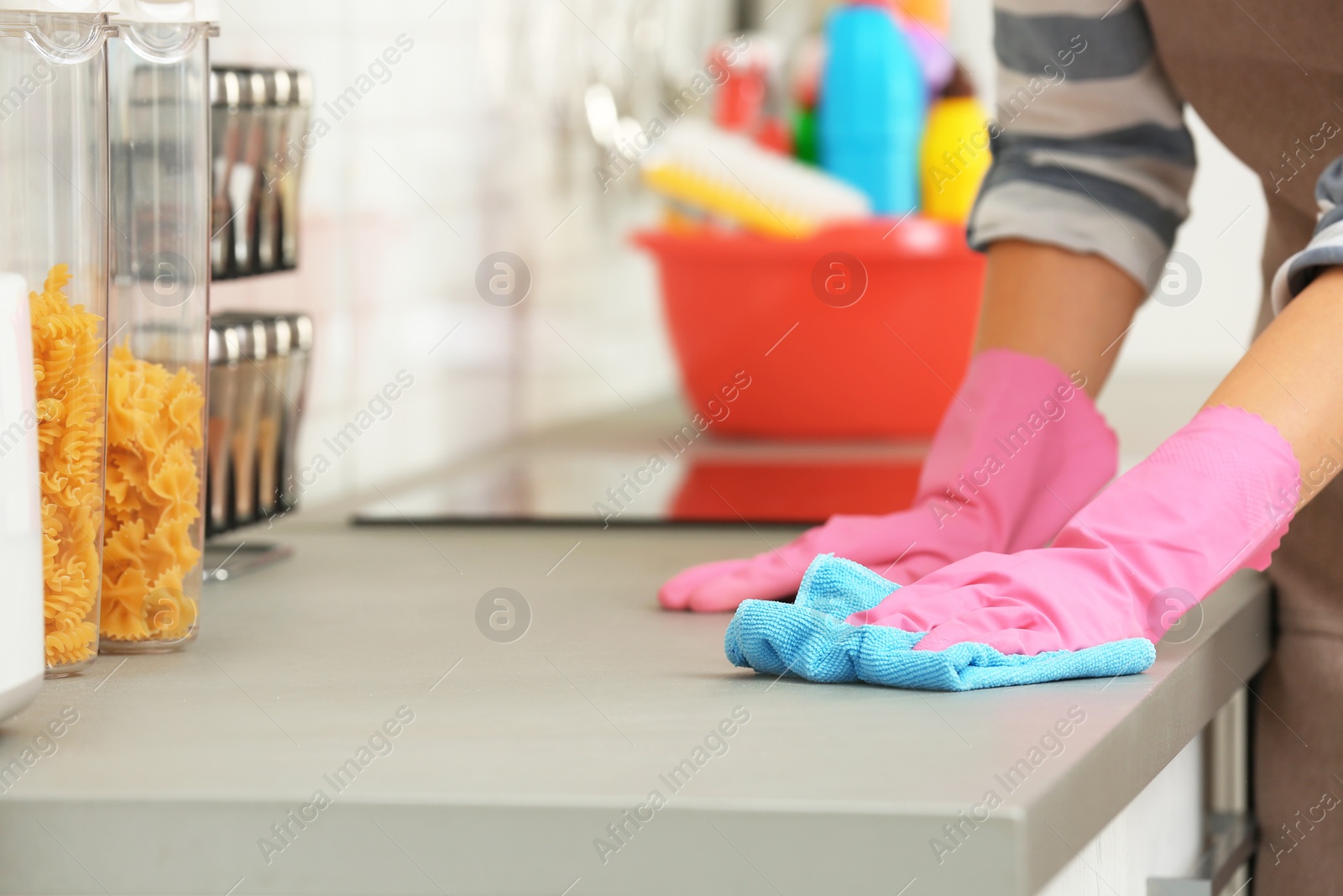 Photo of Woman cleaning kitchen counter with rag, closeup