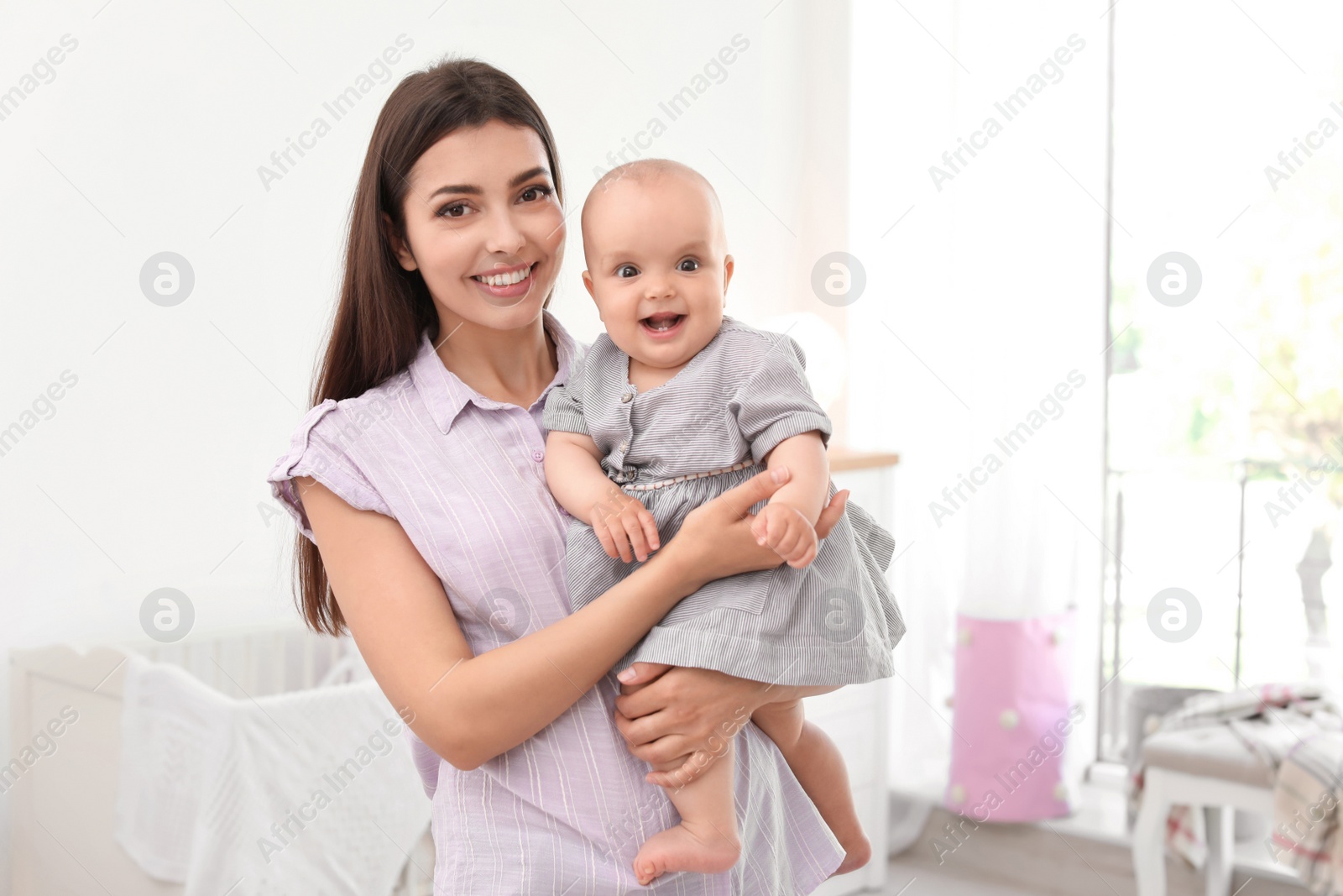 Photo of Young mother with her cute baby girl at home